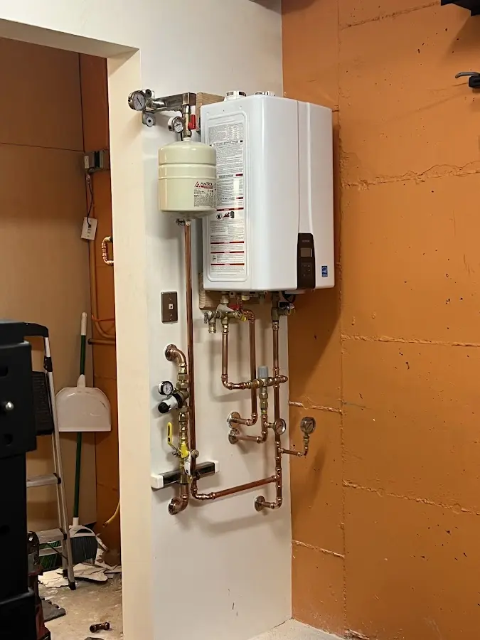 Plumbing technician inspecting water heater connections in Park Ridge